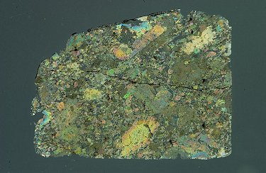Thin Section image in partially Cross-Polarized Light (pyroxene and olivine colors, maskelynite gray, glass veins and chromite black).